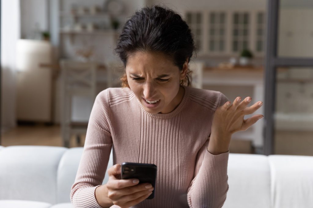 Female divorce client at Clearwater Law Group reads an angry text from her soon-to-be ex, which she will screen shot, to be used in her case against them. 